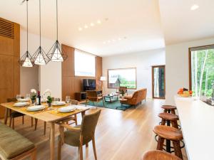 a dining room and living room with a table and chairs at Birchwood Chalet in Niseko
