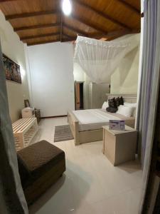 - une chambre avec un lit et un canapé dans l'établissement Vista House Kandy, à Kandy