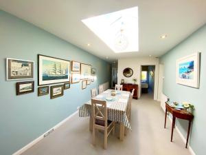 a dining room with a table and some pictures on the wall at Braeside Luxury Holiday Home in Torquay