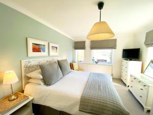 a bedroom with a large bed and a television at Braeside Luxury Holiday Home in Torquay