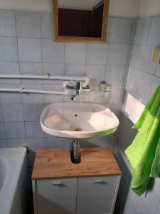 a bathroom with a white sink and a green towel at Kuća za odmor Kalina in Mokra Gora