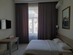 - une chambre avec un lit, un bureau et une fenêtre dans l'établissement Summit Apartments, à Kiev