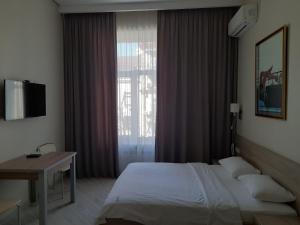 a bedroom with a bed and a desk and a window at Summit Apartments in Kyiv