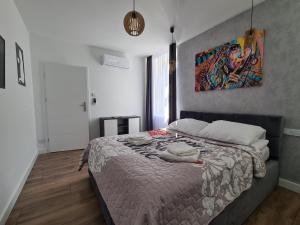 um quarto com uma cama com um quadro na parede em Paderewskiego Old Town Apartaments em Cracóvia