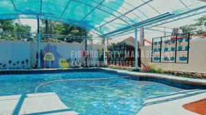 una gran piscina con dosel. en Private Resort in Laguna: Casita de Ruby, en Maitim