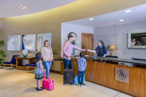 un gruppo di persone in piedi nella hall con bagagli di Manor West Hotel & Leisure Club a Tralee