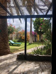 a window view of a park with a bench at Finca Gerardo Miramar in La Playa Calera