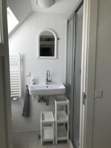 a white bathroom with a sink and a shower at Vlasoven loft in Noordwijkerhout +20 photos