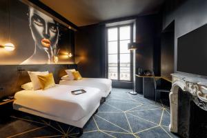 a hotel room with two beds and a tv at Hotel Leprince, Best Western Premier Collection in Le Mans +41 photos