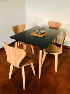 a black dining table with chairs and a bowl of fruit on it at AMANECER Rent Apart - Tú Hogar! Amplio y Luminoso con Desayuno in Junín