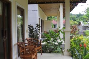 two chairs sitting on the porch of a house at Pondok Aldi in Amed
