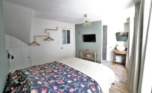 1 dormitorio con 1 cama con una manta estampada con motivos florales en La Roche ô Tour! - Gîte citadin, en La-Roche-en-Ardenne