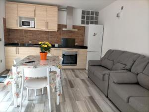 a kitchen and living room with a table and a couch at Casa RITI Mesa del Mar in Tacoronte