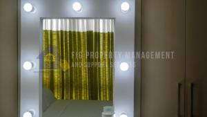a mirror with a reflection of a yellow shower curtain at East Bay Residences @ Sucat Muntinglupa in Manila