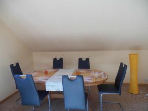 Zimmer mit einem Holztisch und blauen Stühlen in der Unterkunft Ferienwohnung Paul und Maria in Olsberg