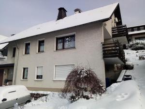 ein Haus mit Schnee auf dem Boden davor in der Unterkunft Ferienwohnung Paul und Maria in Olsberg