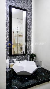a bathroom with a white sink and a mirror at East Bay Residences @ Sucat Muntinglupa in Manila