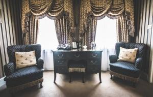 two chairs and a dresser in a room with windows at Jeakes House in Rye