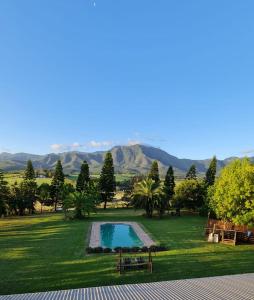 a swimming pool in a yard with mountains in the background at Esperanza Countryside Accomodation in George