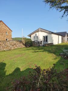 a white barn with a grass yard in front of it at Swallow cottage, Over Kellet in Over Kellet