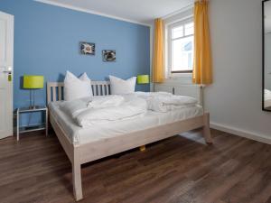 una camera da letto con un letto con lenzuola bianche e una finestra di Villa Binz - Apt. 05 a Binz