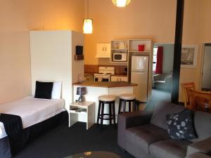 Una pequeña habitación con una cama y una cocina. en Chelmswood Motel Taupo, en Taupo