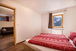 ein Schlafzimmer mit einem roten Bett und einem Fenster in der Unterkunft Golserhof Kristall in Steinhaus