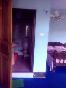- une salle de bains avec toilettes et un lit dans une chambre dans l'établissement Vamoose Rajalim Homestay, à Māngwa