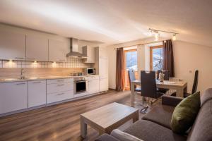 a kitchen and living room with a couch and a table at Golserhof Sonne in Cadipietra