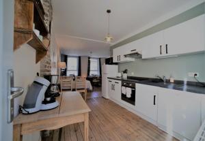 a kitchen with white cabinets and a blender on a counter at La Roche ô Tour! - Gîte citadin in La-Roche-en-Ardenne