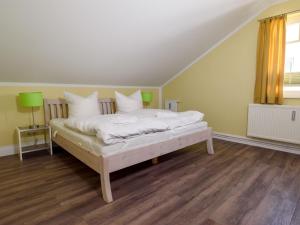Schlafzimmer mit einem Bett mit weißer Bettwäsche und Kissen in der Unterkunft Villa Binz - Apt. 03 in Binz