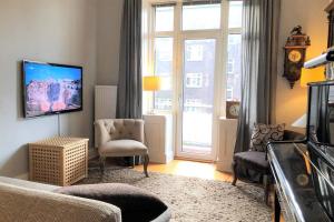 ein Wohnzimmer mit einem Sofa und einem TV in der Unterkunft Stadtpark-Domizil - 70 qm, zentral & ruhig in Hamburg