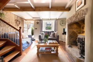 a living room with a couch and a table at Niver Dew Holiday Cottage in Lower Boscaswell