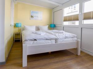 białe łóżko w pokoju z oknem w obiekcie Villa Binz - Apt. 02 w mieście Binz