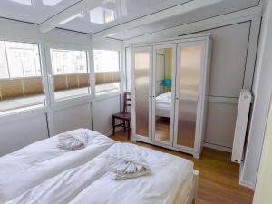 sypialnia z białym łóżkiem i 2 oknami w obiekcie Villa Binz - Apt. 02 w mieście Binz