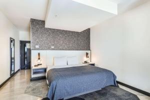 ein Schlafzimmer mit einem großen Bett und einer weißen Wand in der Unterkunft Hy-Lo Hotel, Ascend Hotel Collection in Calera