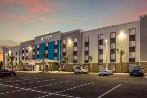 a rendering of the exterior of a hotel parking lot at WoodSpring Suites Jacksonville Baymeadows in Deerwood Club