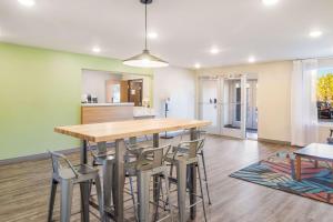 a kitchen and dining room with a wooden table and chairs at WoodSpring Suites Jacksonville Baymeadows in Jacksonville