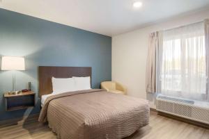 a bedroom with a large bed and a window at WoodSpring Suites Jacksonville Campfield Commons in Jacksonville