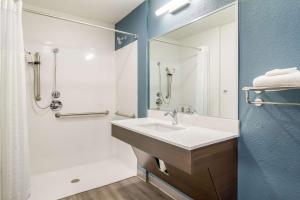 a bathroom with a sink and a shower and a mirror at WoodSpring Suites Jacksonville Baymeadows in Deerwood Club +24 photos