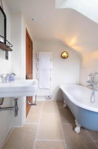 a bathroom with two sinks and a bath tub at Niver Dew Holiday Cottage in Lower Boscaswell +17 photos