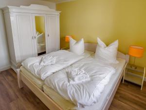 a white bed with white sheets and pillows on it at Villa Binz - Apt. 01 in Binz
