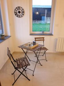 a table and chairs in a room with a window at La Clef des Champs in Potelle