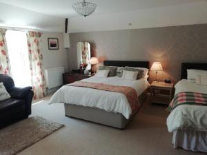 a bedroom with two beds and a couch at Rectory Farm in Haverfordwest