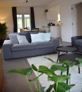 ein Wohnzimmer mit einem Sofa und einem Tisch in der Unterkunft Gîte le 44 - au calme avec jardin, proche de Namur in Namur