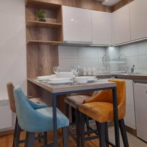 una cucina con tavolo, sedie e armadi di apartman i spa Luka Zlatibor a Zlatibor