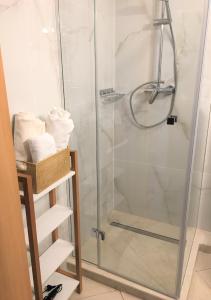 a shower with a glass door in a bathroom at Apartament Agaciula in Krynica Morska