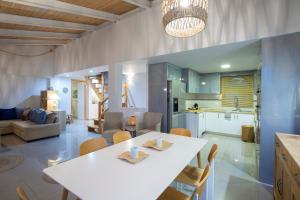 een keuken en een woonkamer met een witte tafel en stoelen bij SKAI Two Floor Apartment in Vasiliki