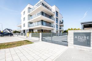 a white apartment building with a sign in front of it at AZURE PREMIUM Dreams in Kołobrzeg