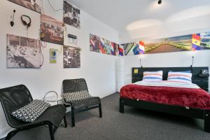 a bedroom with a bed and two chairs at BEDbijPET in Emmen